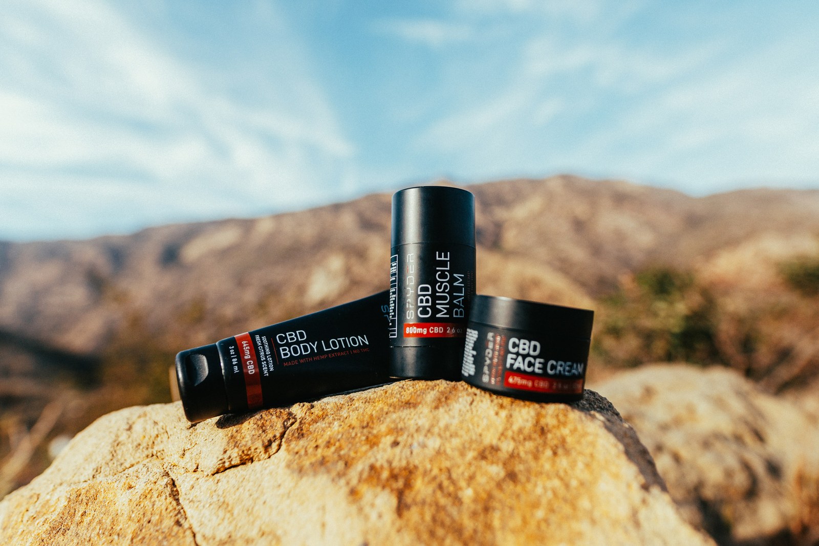 Spyder CBD range grouped on a boulder with a mountain ridge behind