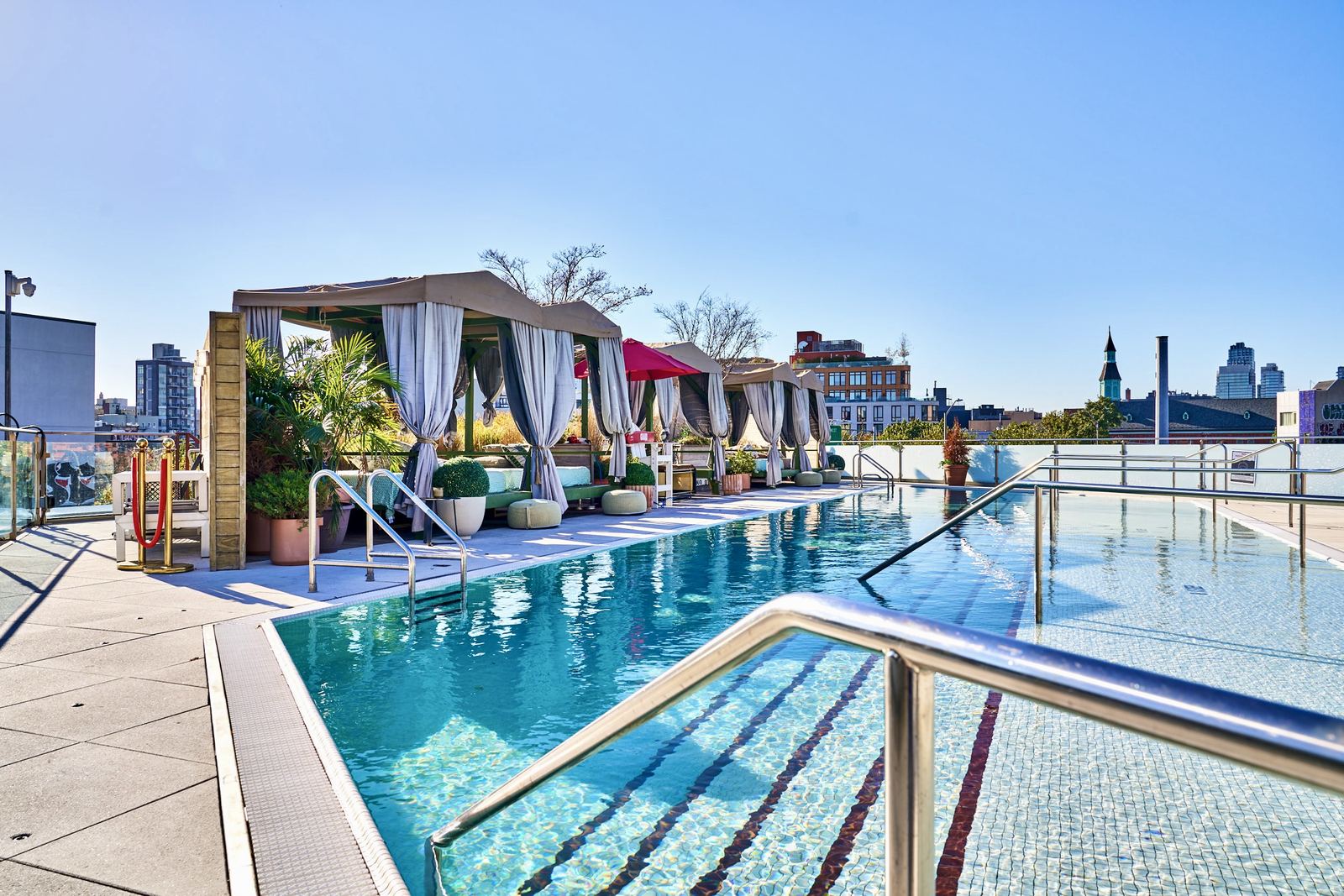 Rooftop pool deck at Hotel Indigo with the city skyline behind