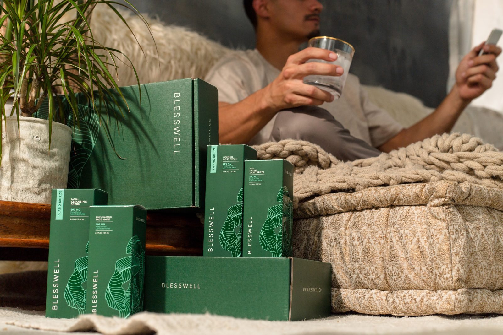 BLESSWELL cartons stacked beside a bed with soft daylight behind