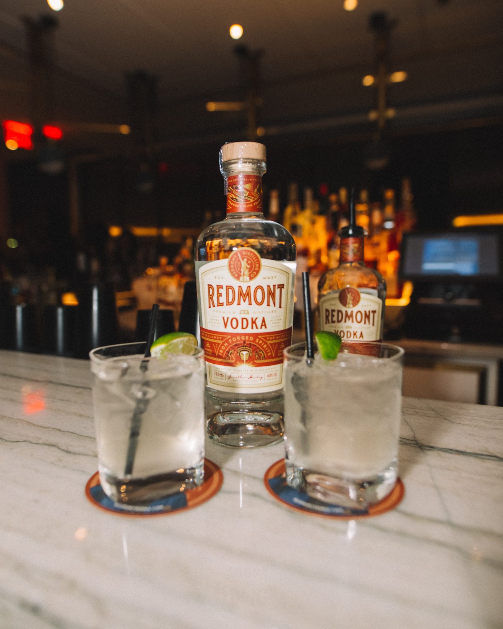 Redmont Vodka bottle and two finished serves on the marble bar at the Conrad New York launch