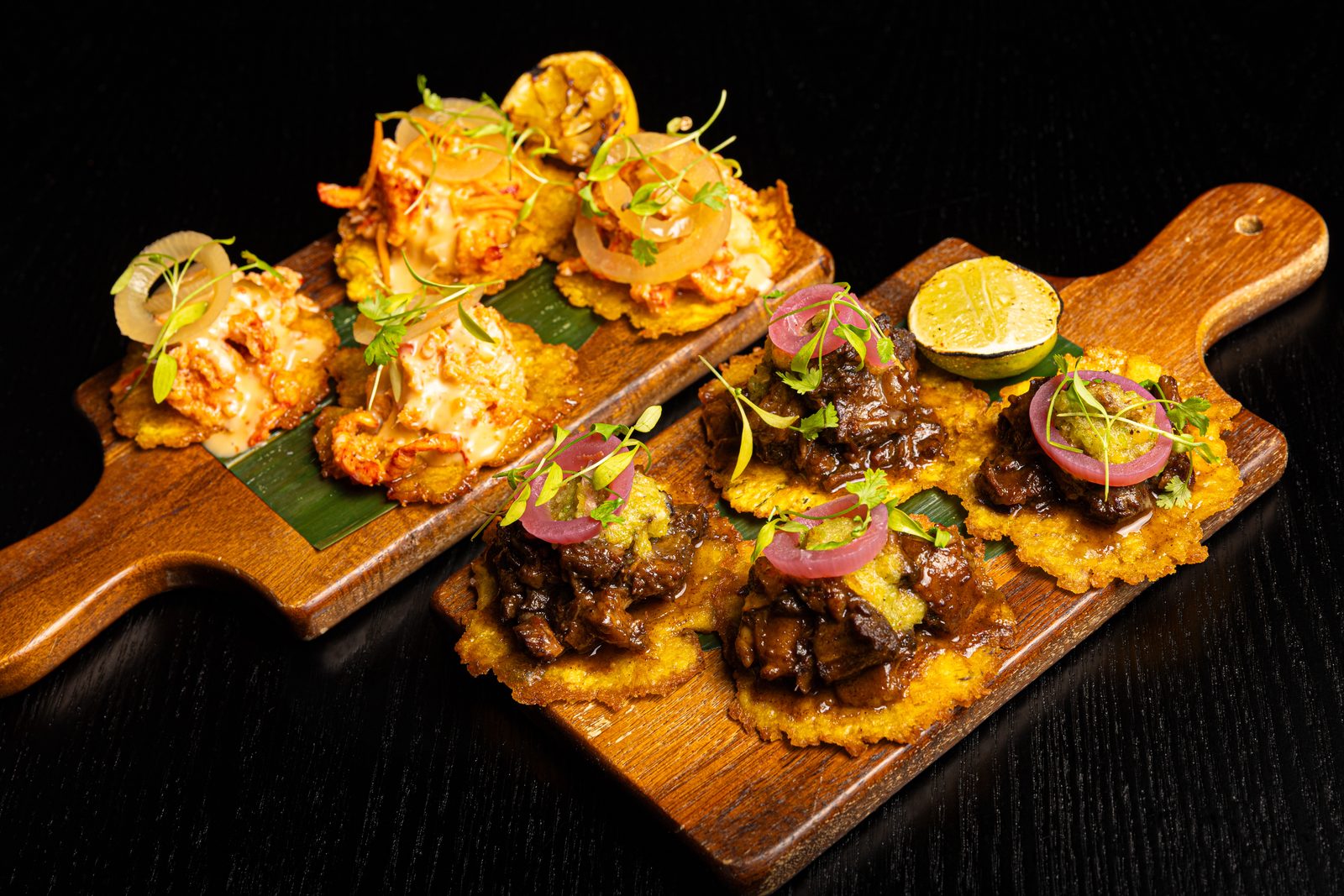 Board of lobster and oxtail tostones plated for service at Aliya Cocktail Den