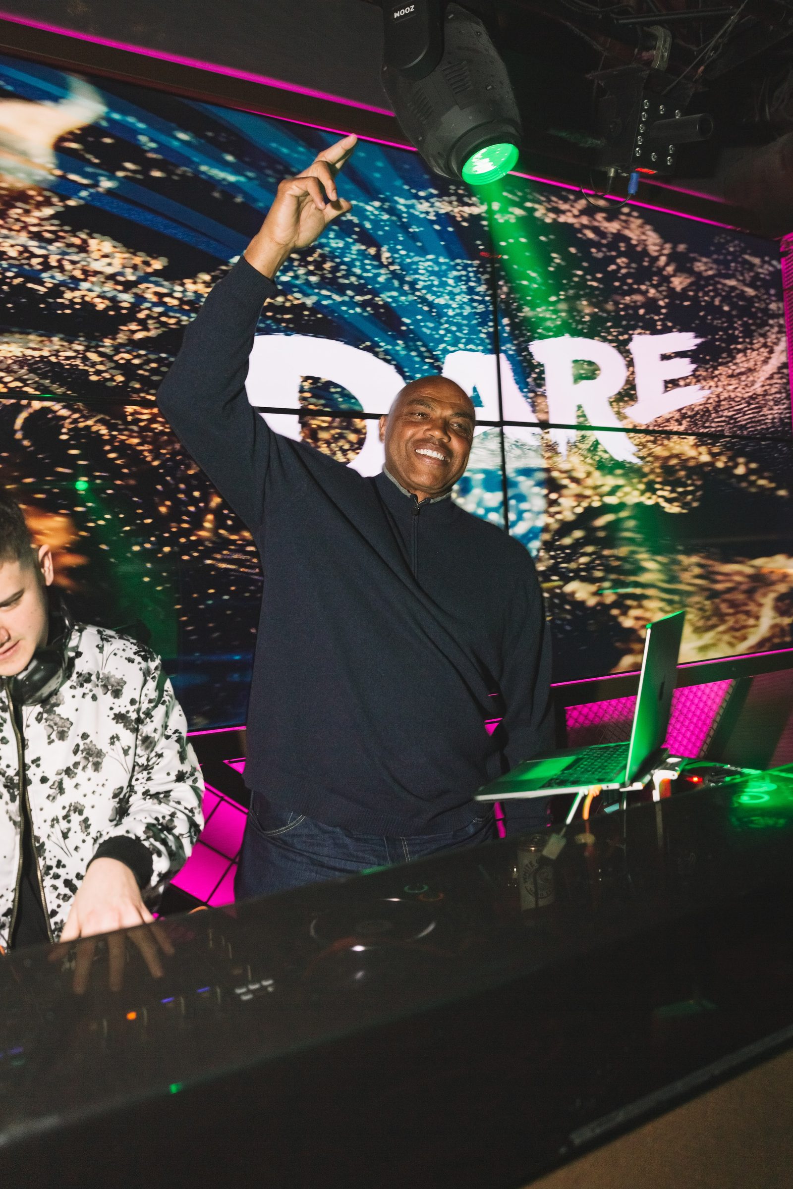 The DJ booth lit by the screen wall during the activation