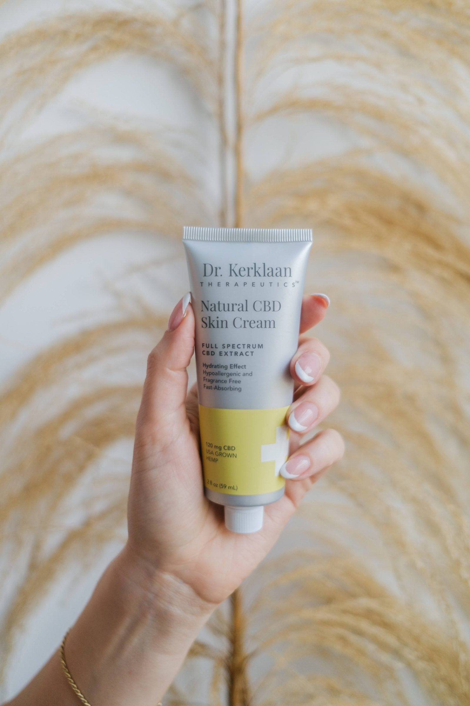 Dr. Kerklaan skin cream held against dried pampas grass