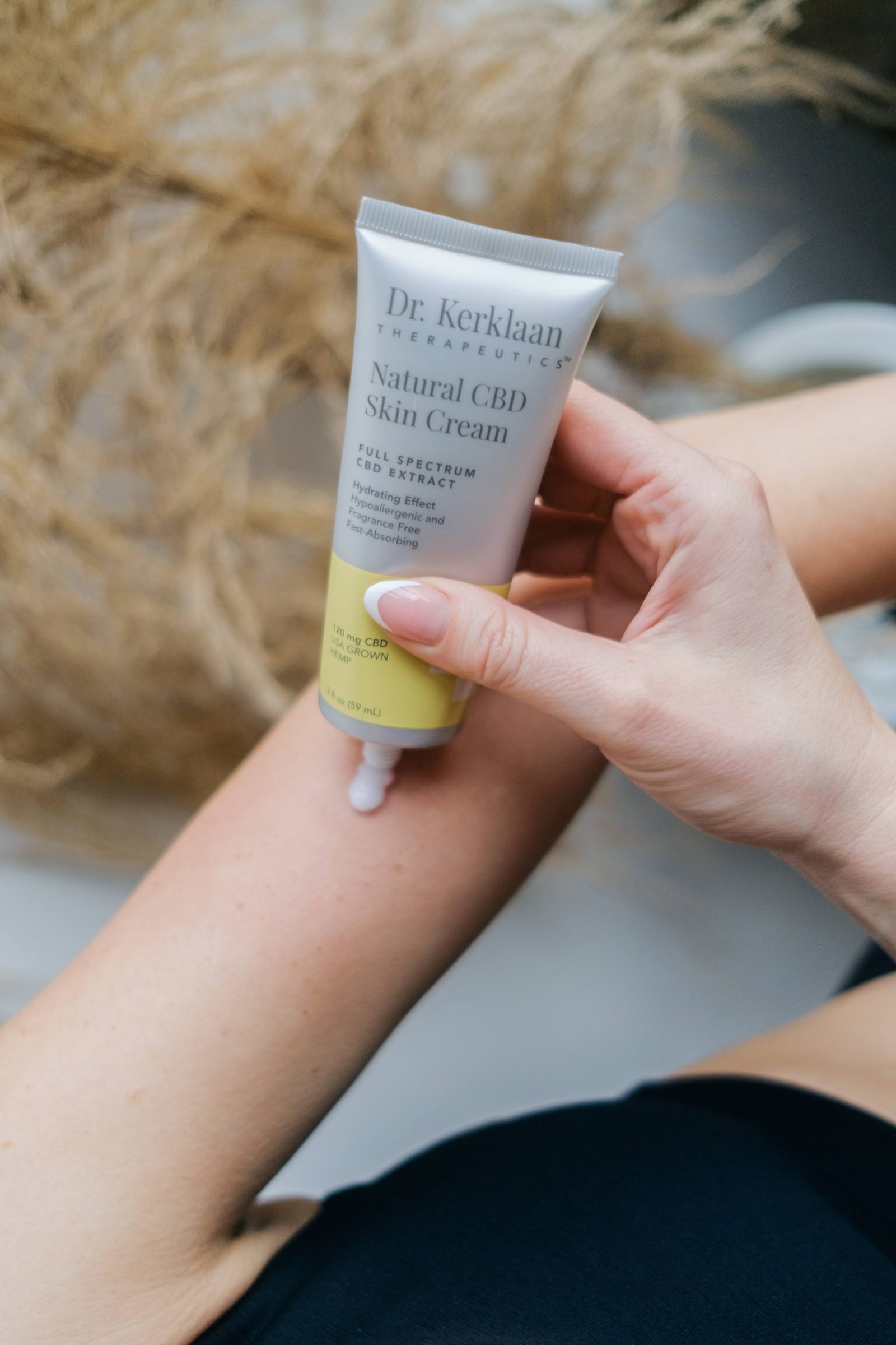 Hands holding a Dr. Kerklaan skin cream tube in daylight